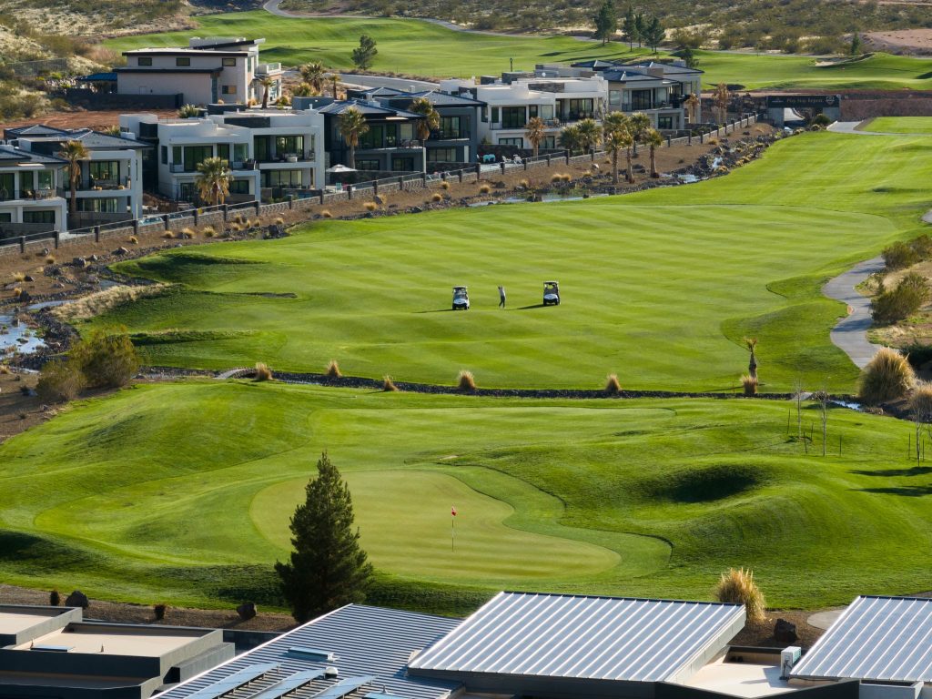 Aerial view of Copper Rock golf course and luxury homes in Hurricane, Utah — championship course surrounded by copper-colored cliff formations