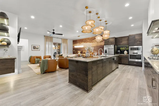 Open kitchen with dark island and sculptural pendants