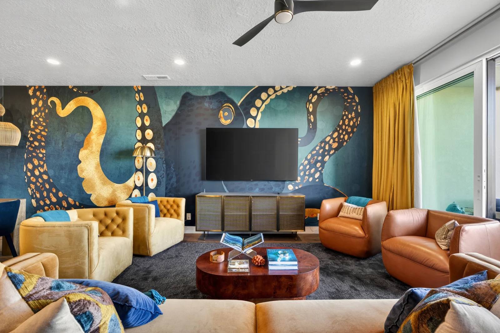 Octopus living room with leather sofas, yellow chairs and blue rug
