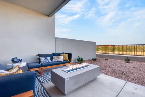 Covered patio with blue seating, fire table and outdoor dining