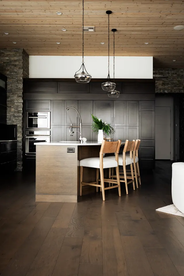 Dark wood kitchen beneath a wood-plank ceiling