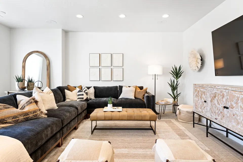 Living room with a charcoal sectional and carved console at Cyanne Lane